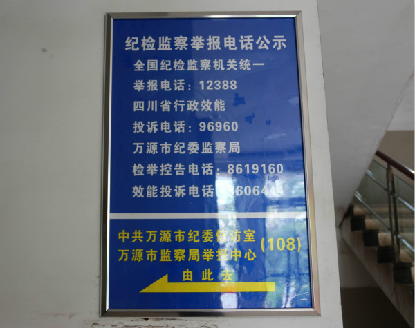 图为万源市纪检监察举报电话公示牌